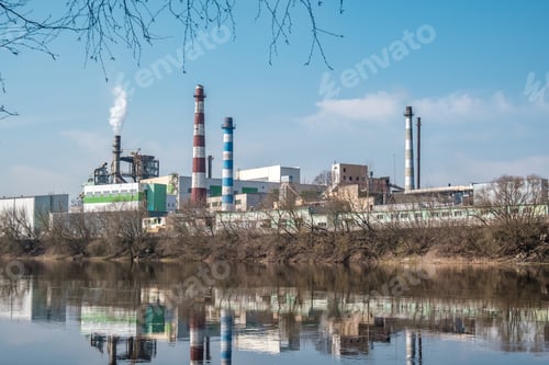 Preview: pipes of woodworking enterprise plant sawmill near river. Air pollution concept.