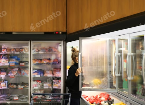 Preview: Woman Choosing Frozen Food From A Supermarket Freezer
