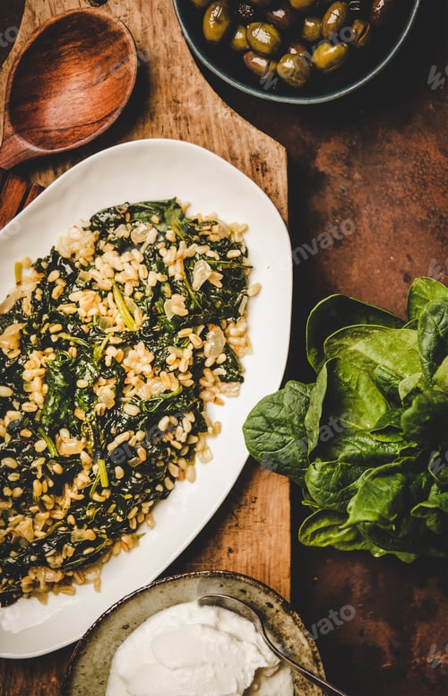 Preview: Flat-lay of Turkish traditional dish Bulgur and spinach on board