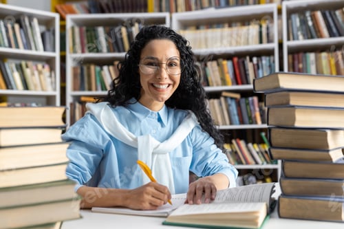 Preview: Smiling Hispanic student studying with books at the library