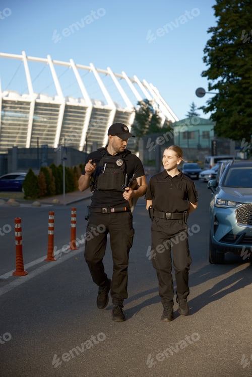 Preview: Friendly smiling patrol police officers outdoor