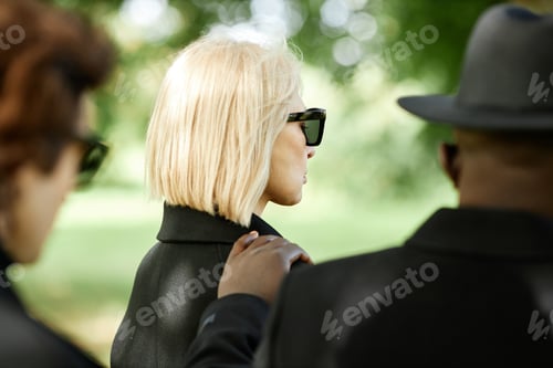 Preview: Woman wearing dark sunglasses at funeral