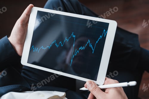 Preview: Businessman, investor,trader analyzing,looking at chart of stock prices in tablet. CEO,general manag