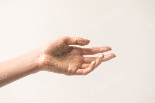 Preview: Cropped image of female hand in golden glitter isolated on beige