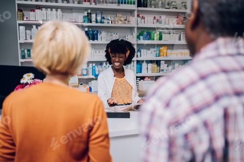 Preview: Smiling african american woman pharmacist working at the counter in a pharmacy