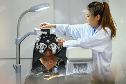 Preview: Beautiful female ophthalmologist examining eyesight of child patient special ophthalmic glasses.