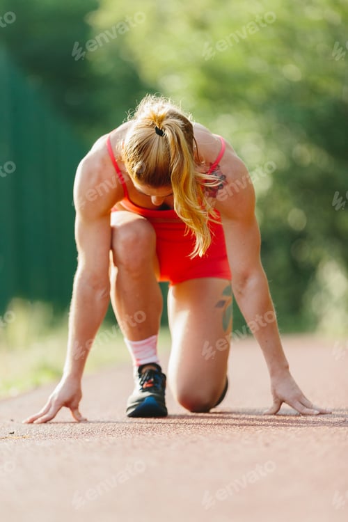 Preview: Female runner starting race on track outdoors
