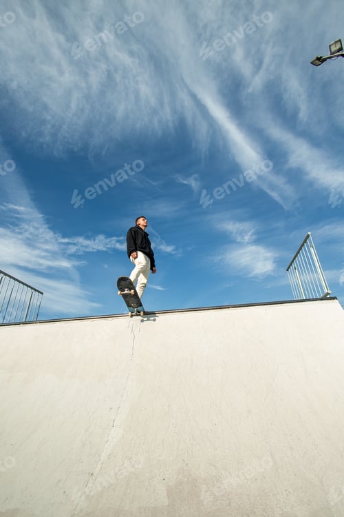 Preview: vertical Fish-eye view of a skater enjoying the sun, gazing at the sky