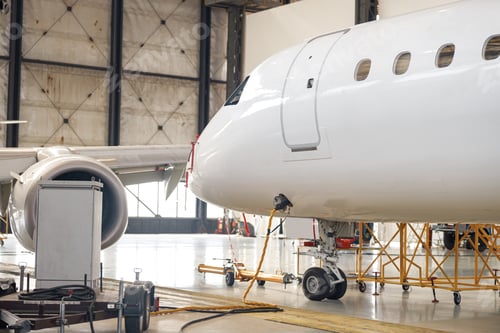 Preview: Modern new white passenger airplane on maintenance repair check in airport hangar indoors