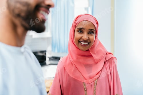 Preview: Happy middle eastern couple wearing traditional arab clothing at home