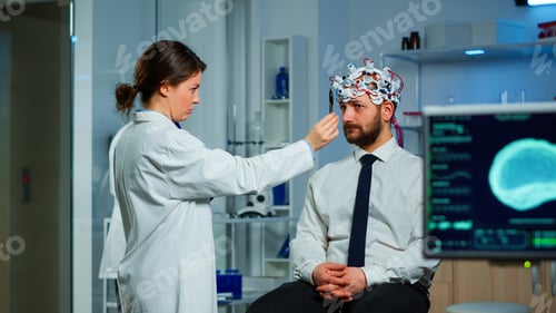 Preview: Man sitting on neurological chair with brainwave scanning headset
