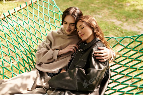 Preview: Young couple enjoys a cozy moment together in a hammock amidst natures beauty