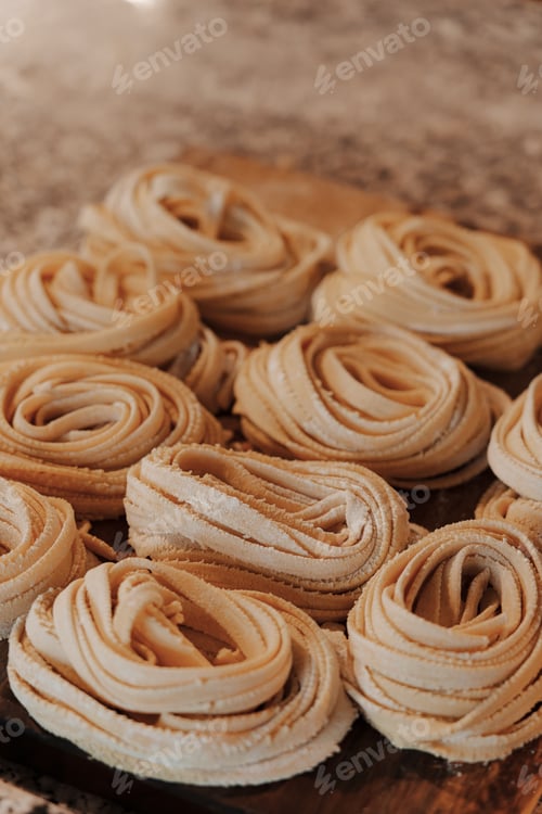 Preview: Delicious raw rolled tagliatelle pasta on table