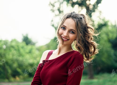Preview: Portrait of young beautiful woman outdoors on green summer nature background