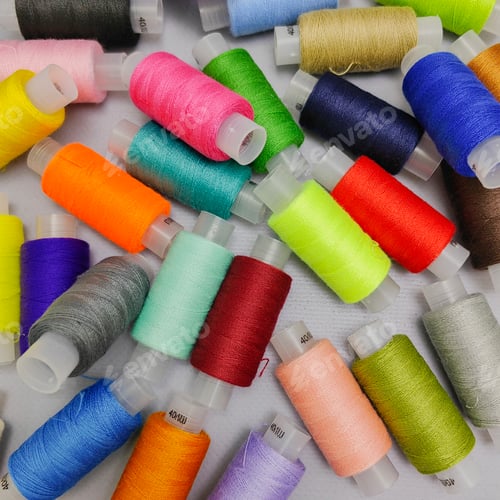 Preview: background of coils on which colored sewing threads are wound