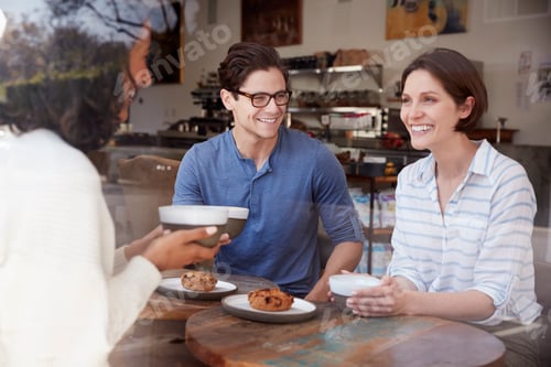 Preview: Three friends talking and drinking coffee at a coffee shop