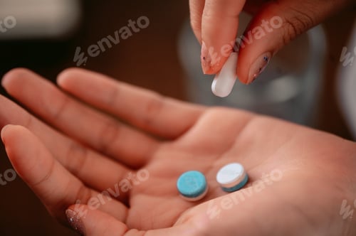 Preview: A woman hold white and blue pills in her hands. Concept of healthcare and medicine, Close up pills.