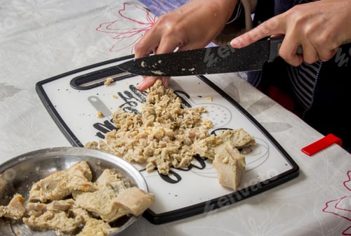 Preview: Cutting boiled pork tripe on the cutting board at the table in the kitchen