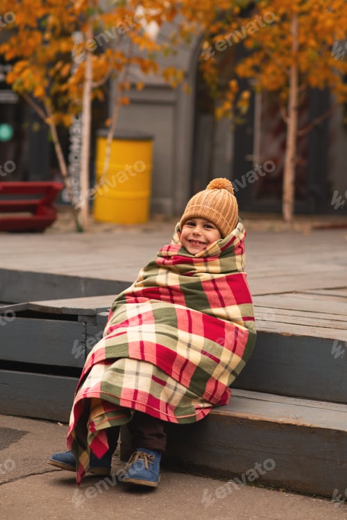 Preview: Little pretty girl in hat and plaid blanket outdoor, city street, autumn and winter season