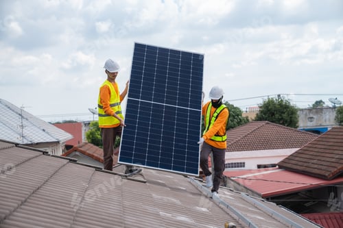 Preview: Service engineer installing solar cell on the roof of house. Technicians working about solar panel.
