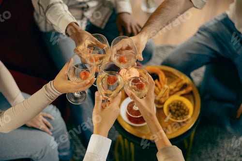Preview: Top view of people toasting with wine glasses while celebrating at dinner party together