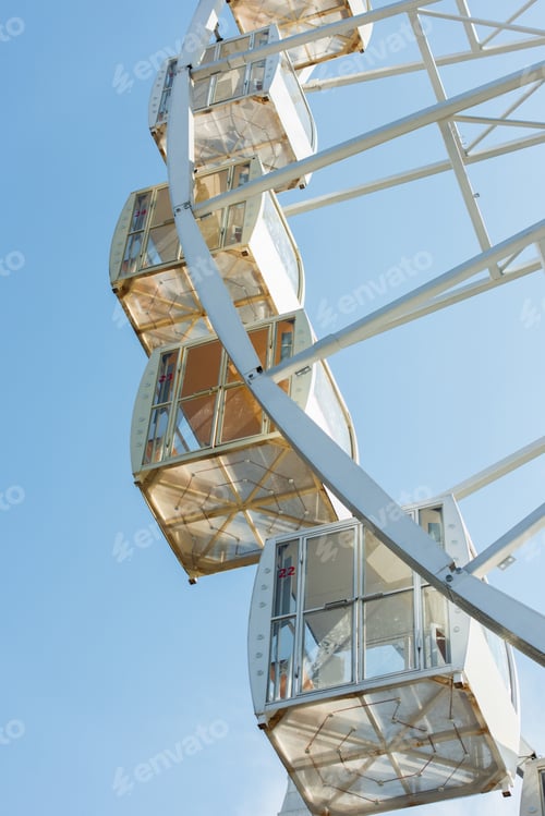 Preview: cabins of observation wheel against blue sky in amusement park