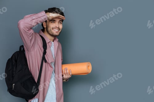 Preview: Active Tourism. Nice Joyful Positive Man Wearing Rucksack And Looking Far Away While Having A