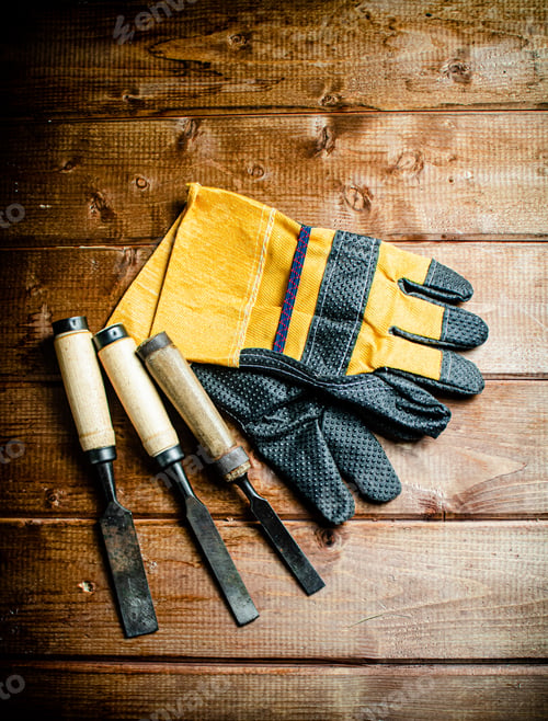 Preview: Chisel with construction gloves on the table.