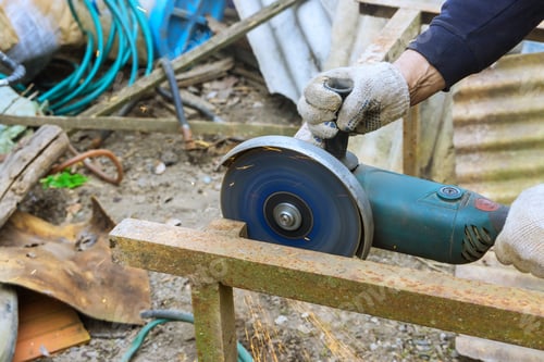 Preview: Using an angle grinder hand saw, a worker cuts metal frames