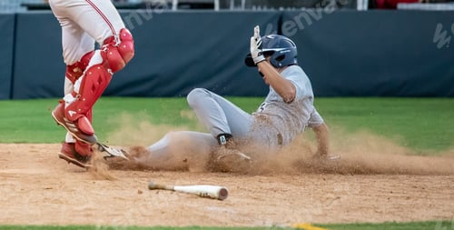 Preview: A high school baseball game where a player is sliding into home plate