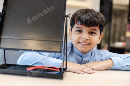 Preview: Happy Indian child boy wearing sunglasses in glasses shop.