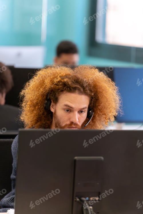 Preview: Man with headset intensely focusing at work.