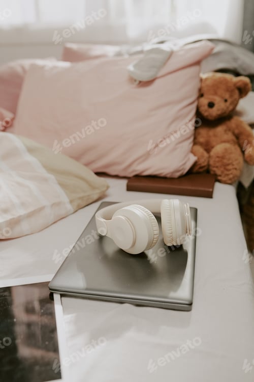 Preview: Cozy Bed with Plush Bear and Headphones on Laptop