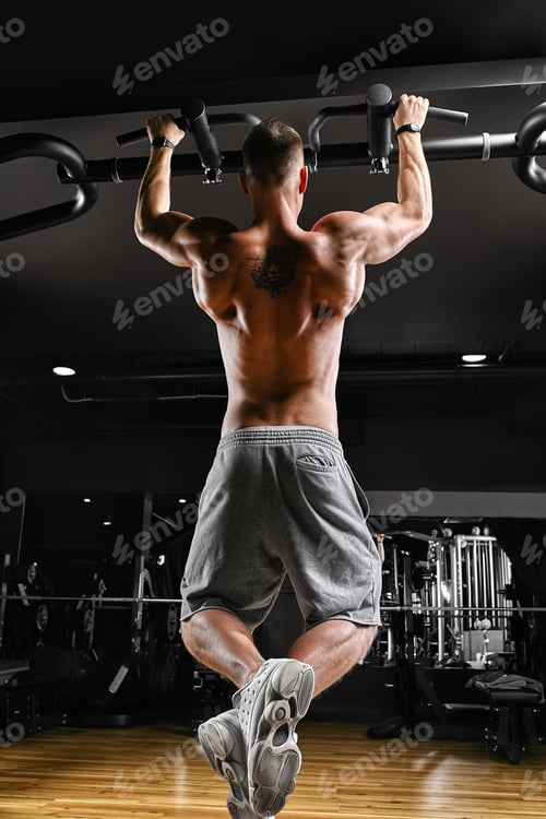 Preview: The athlete does a pull-up on the horizontal bar. A man in great shape is doing pull-ups on the