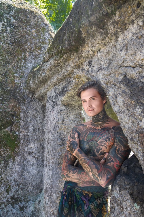Preview: portrait of shirtless tattooed man standing at ruins in bali, indonesia