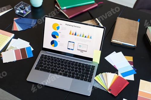 Preview: Above angle of laptop with financial information on screen standing on workplace