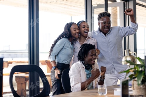 Preview: Diverse team celebrating success in modern office, showing excitement and teamwork