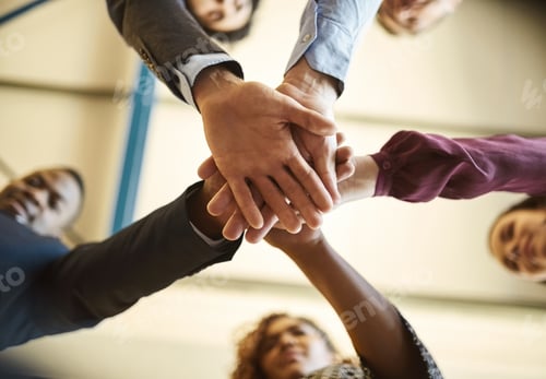 Preview: Low angle shot of a team of businesspeople piling their hands on top of each other in the office
