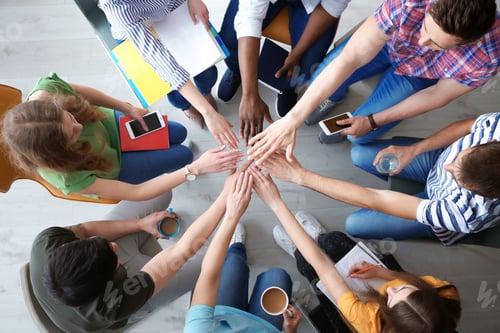 Preview: People putting hands together indoors, top view. Unity concept