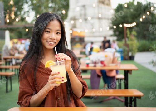 Visualização: Jovem mulher desfrutando de limonada refrescante no festival de verão ao ar livre