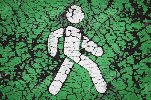 Preview: Pedestrian icon on green. Cracked paint on asphalt. Go green and pedestrian priority concept