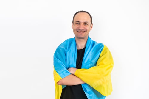 Preview: Handsome man with flag of Ukraine at home.