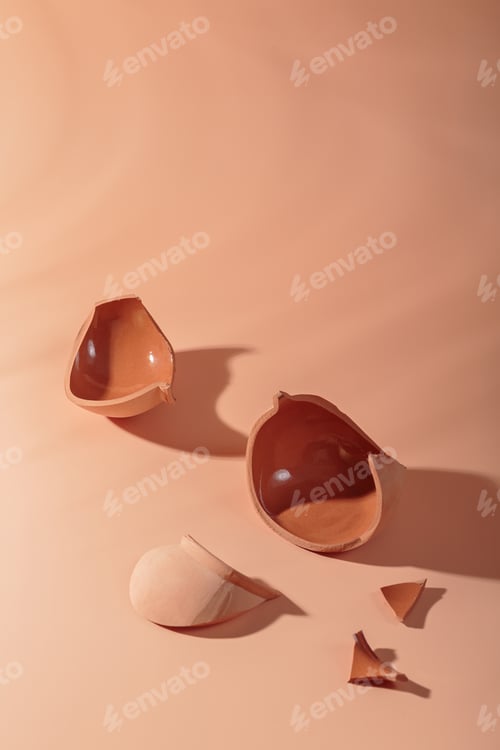 Preview: Details of broken ceramic cup on beige background