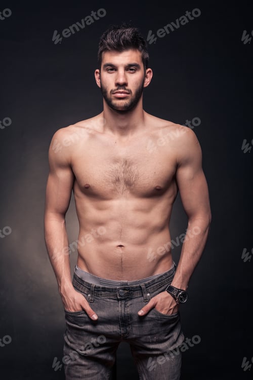 Preview: One Young Adult Handsome Man, Shirtless, Hands In Pockets, Black Background Studio