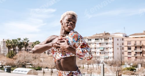 Preview: Cheerful black queer person showing heart gesture and smiling on street