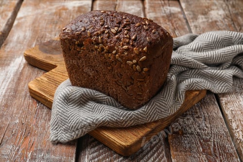 Preview: Fresh loaf of bread on wooden table, closeup