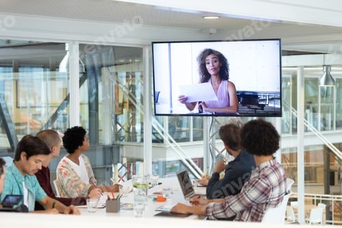 Preview: Diverse business people attending video conference at conference room in a modern office