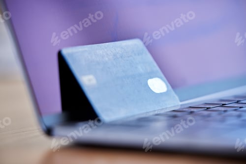 Preview: Shot of a credit card and laptop on a desk in an empty office during the day