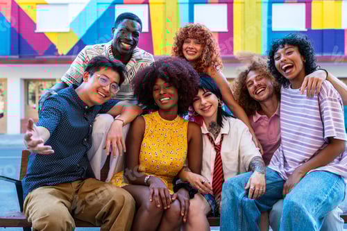 Preview: Multiethnic group of young friends meeting and having fun outdoors