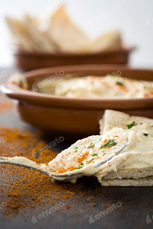 Preview: Creamy hummus with pita bread, paprika, and parsley being served